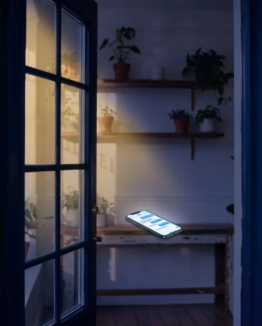 La tienda cerrada de noche, con un celular sobre el mostrador iluminado por un chat