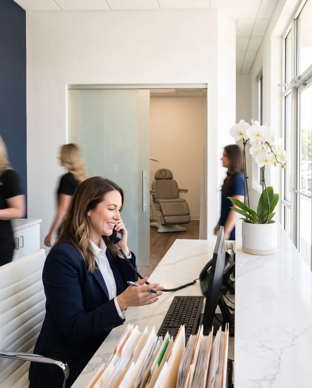 A med spa front-desk coordinator confirms an appointment on the phone at the reception counter